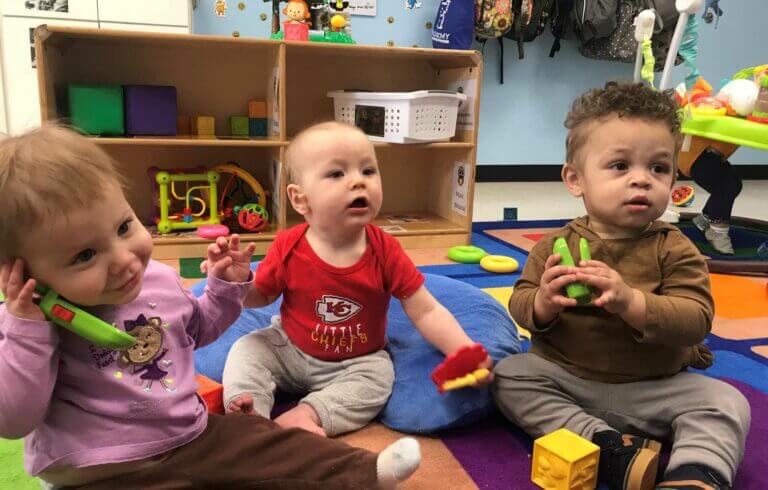 3 Infants are playing with toys on floor at preschool