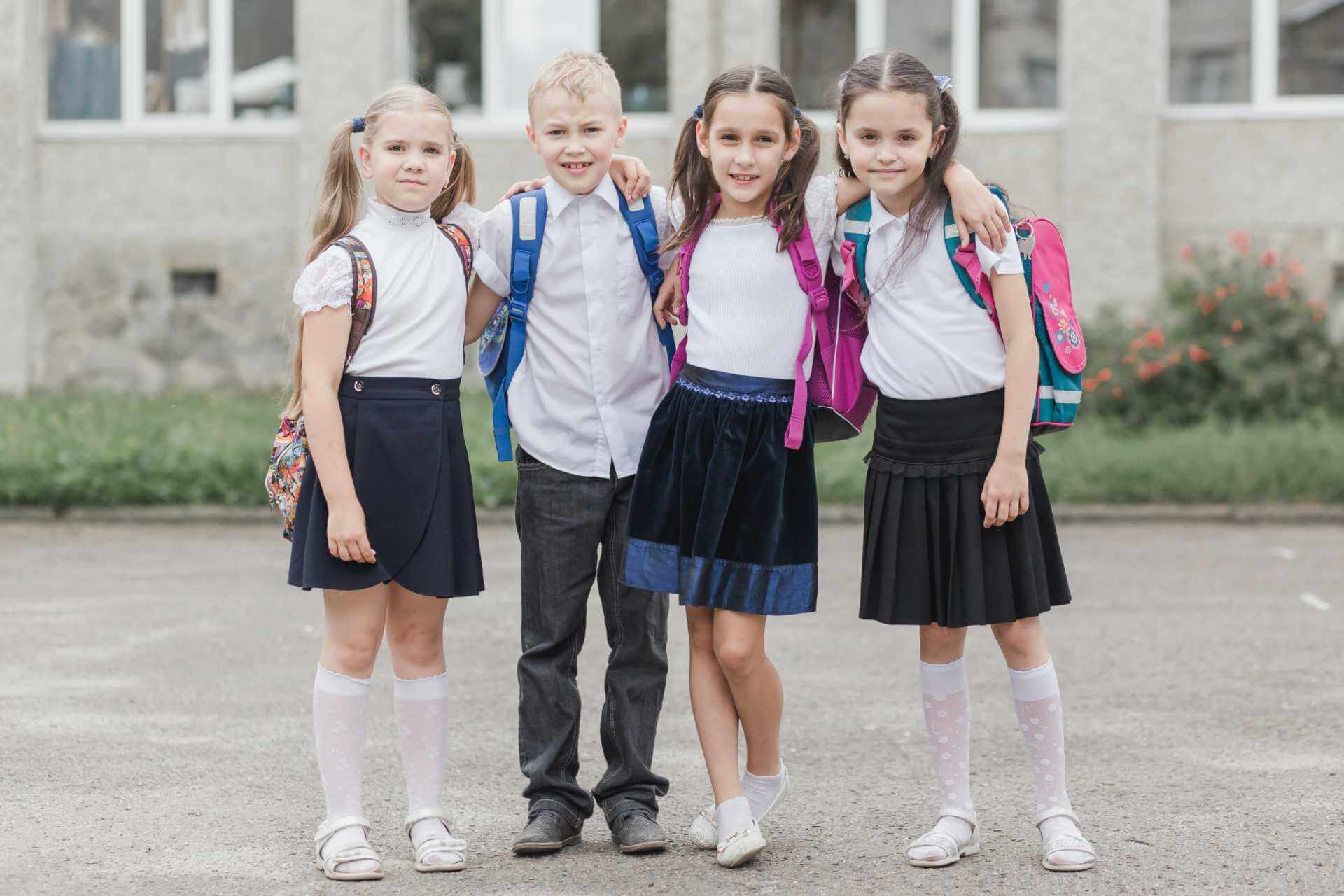 boy and girls are in school uniform and hugging each other in school