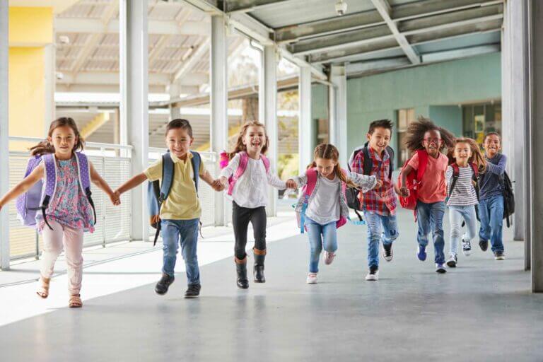 primary-school-kids-run-holding-hands-in-corridor