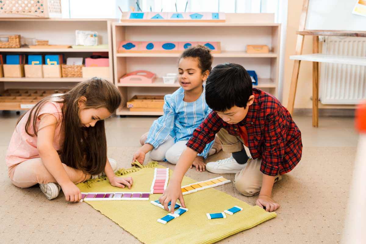 Children playing educational game on floor in montessori school